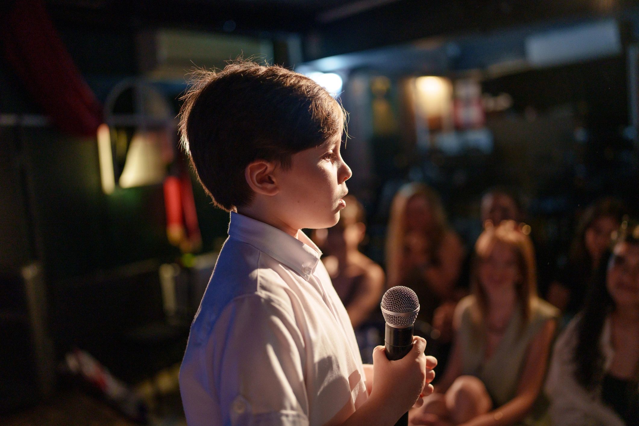 Boy speaking on stage with microphone